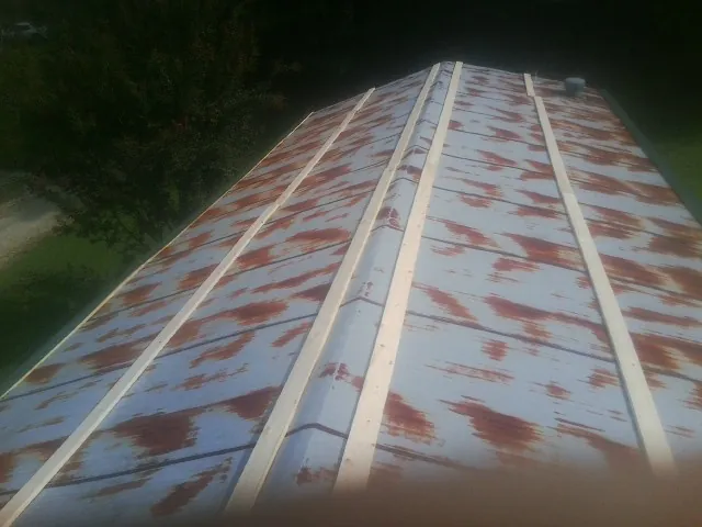 Rusted metal roof panels with new wood purlins before replacement — Storm Damage Roof Repair in Bartlesville by Roofing Brothers