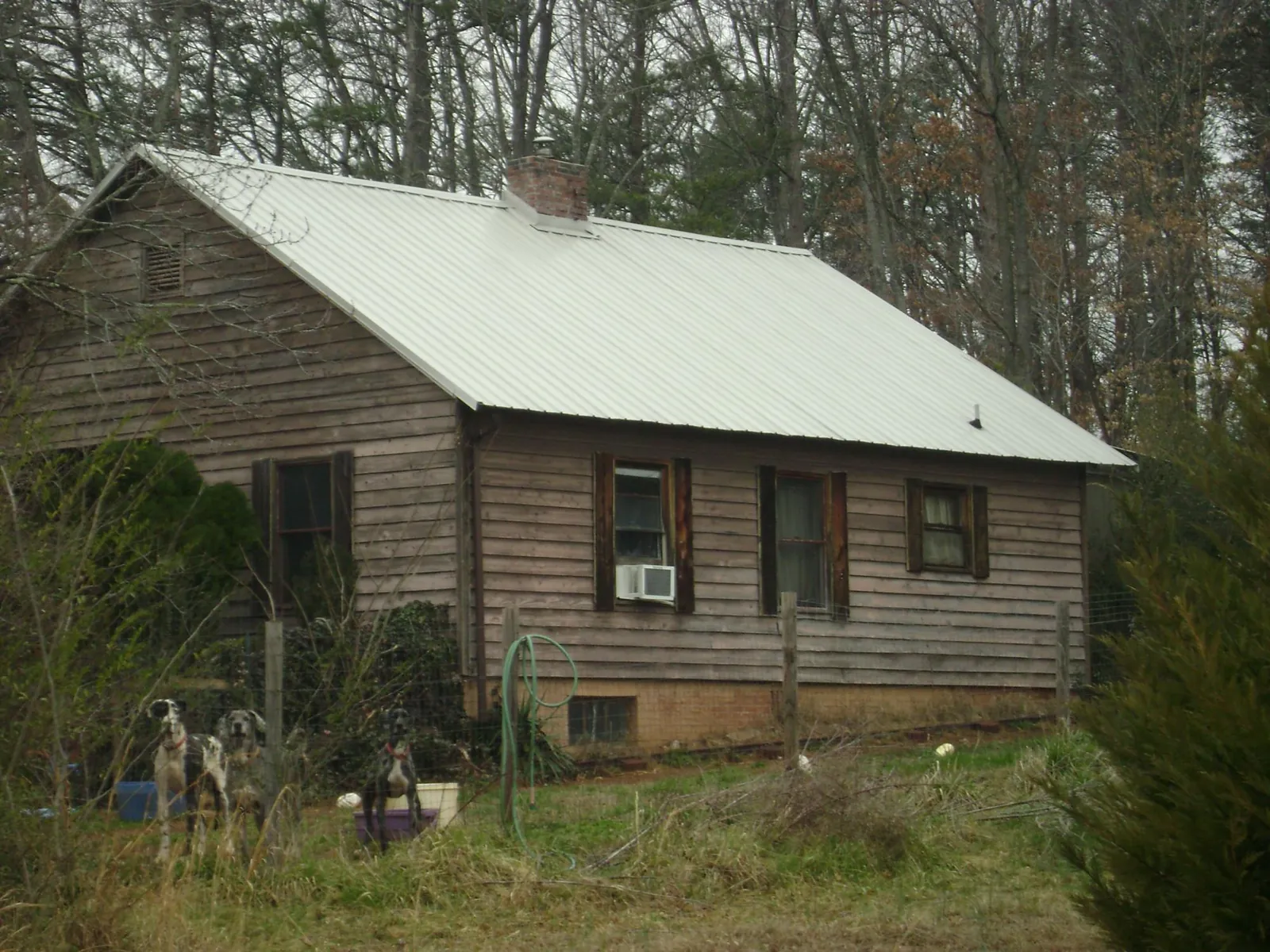 White metal roof on an old wood sided farmhouse, from a Asphalt Shingle Roof Repair job in Bartlesville